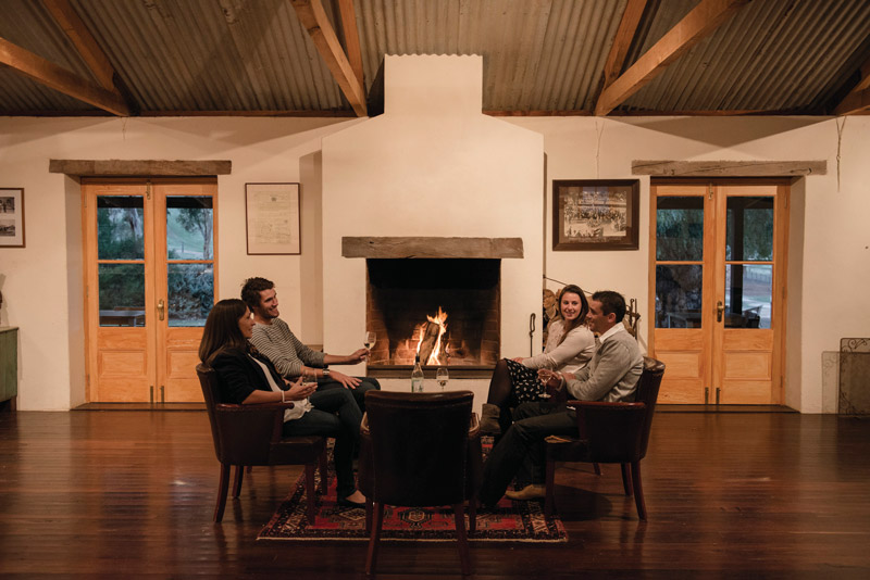4 people drinking in front of fire